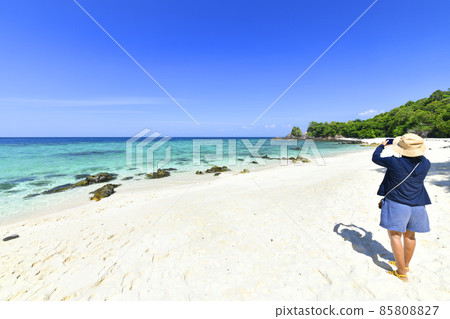 Young woman taking photo with her phone of the view beach at Kho Khai near Tarutao National Marine Park in Satun, Thailand 85808827