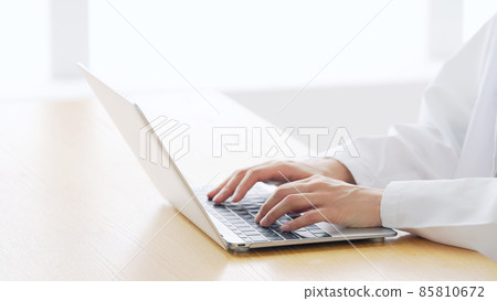 一個穿著白大褂的女人使用電腦 85810672