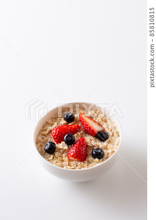 Oatmeal topped with strawberries and blueberries 85810815