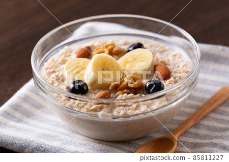 Oatmeal topped with fruits and nuts 85811227