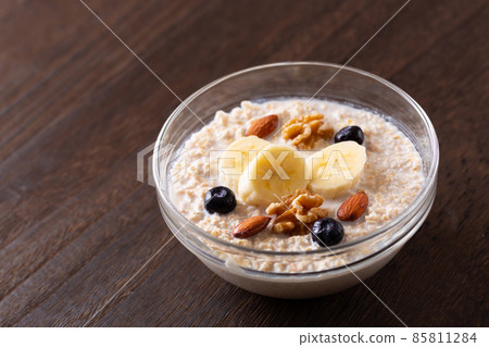 Oatmeal topped with fruits and nuts 85811284