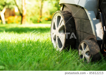 Lawn mower on grass closeup view. Lawn care concept 85812213