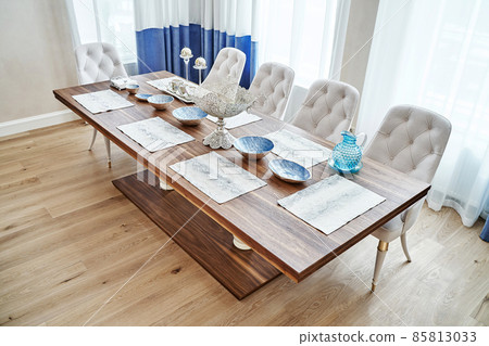 Dining table of walnut with festive setting and armchairs 85813033