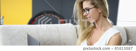 Beautiful young woman with tattoo works with laptop 85813087