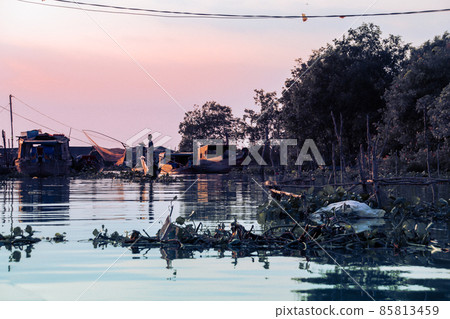 Silhouette of a fisherman casting a fishing net in the Mekong Delta showing the life and culture of the Vietnamese people 85813459