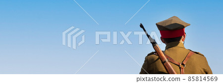 Soldier with rifle on his back against blue sky. Panoramic view. Soldier with rifle on his back against blue sky. Panoramic view. 85814569