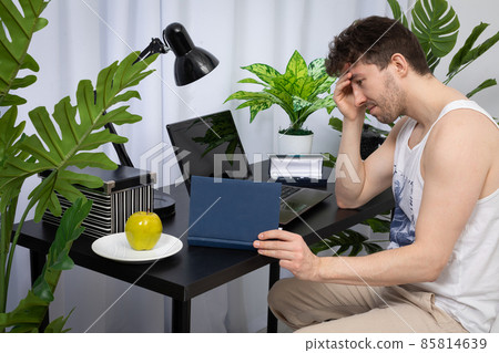 The employee worries about the next meeting in order to conduct the conversation well. A domain computer workstation among potted plants with bright lighting. 85814639