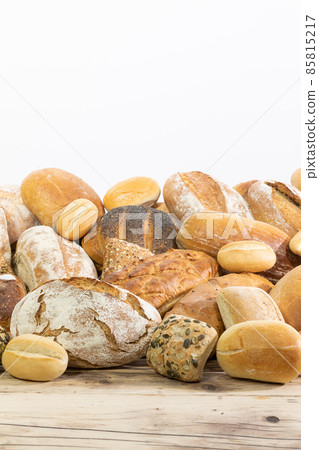 Many kinds and kinds of bread collected in one place on a wooden old shop counter as a decoration for a traditional bakery. White background from the top for self-completion. 85815217