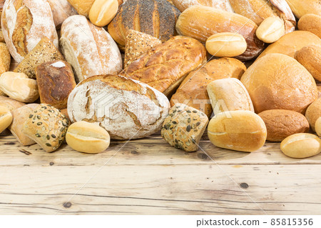 Many kinds and kinds of bread collected in one place on a wooden old shop counter as a decoration for a traditional bakery. White background from the top for self-completion. 85815356