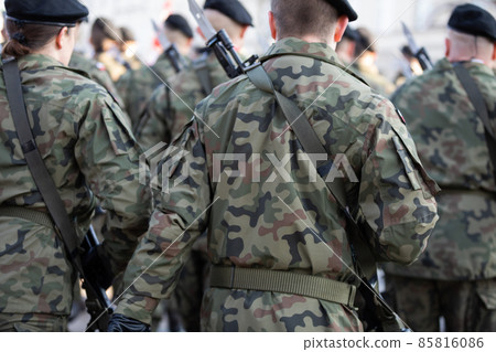 Young soldiers in black berets with guns and bayonets holstered. 85816086