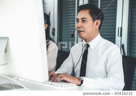 Businessman wearing headset working actively in office Businessman wearing headset working actively in office 85816232