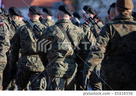 Young soldiers in black berets with guns and bayonets holstered. 85816556