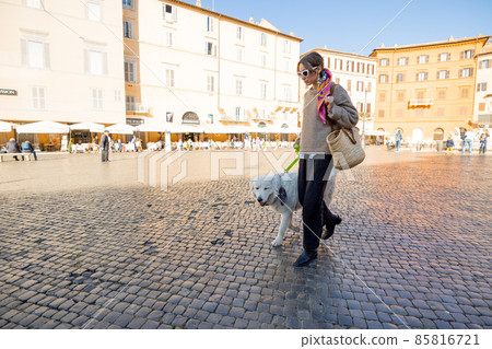 Woman walks with italian shepherd dog on Navona square in Rome Woman walks with italian shepherd dog on Navona square in Rome 85816721