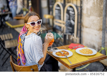 Woman eating italian pasta at restaurant on the street in Rome 85816752
