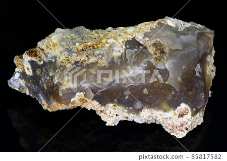 Chipped bluish-gray chalcedony on a black background close up, mineralogical sample. Deposit Russia Chipped bluish-gray chalcedony on a black background close up, mineralogical sample. Deposit Russia 85817582