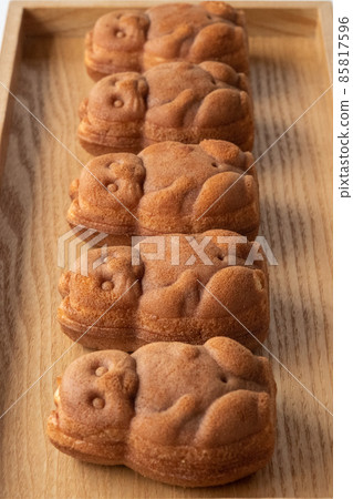 Five raccoon dog ningyo-yaki lined up on a wooden tray 85817596