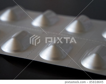 A package of pills on a black background, a close-up shot. A package of pills on a black background, a close-up shot. 85818645