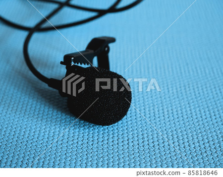 Lavalier microphone on a blue background, close-up. A lavalier microphone or lavalier is a small microphone used for television, theater, and public speaking. 85818646