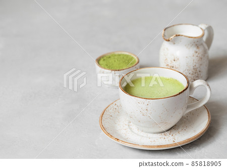 Matcha latte, matcha powder and milk on a gray concrete background. Japanese green tea. Copy space 85818905
