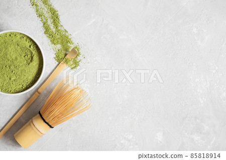 Matcha green tea powder, bamboo whisk and spoon on a gray background. Japanese drink. Tea ceremony. Copy space, top view, flat lay. 85818914