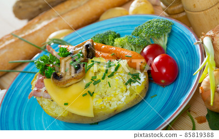 Baked potato with bacon, vegetables, mushrooms Baked potato with bacon, vegetables, mushrooms 85819388