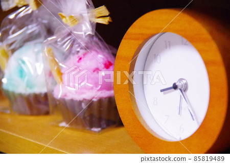 An alarm clock that tells the time and a candle like a candy 85819489