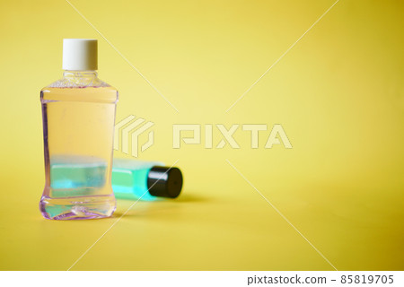 mouthwash liquid in a container on yellow background mouthwash liquid in a container on yellow background 85819705