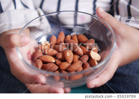 child holding a bowl of almond child holding a bowl of almond 85819709