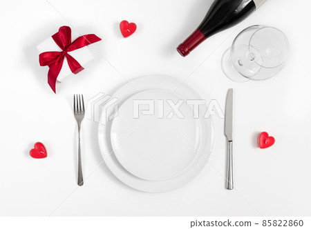 Valentines day or romantic dinner background. Festive romantic table setting with candles, wine and a gift on a white background. Valentine's card. Valentines day or romantic dinner background. Festive romantic table setting with candles, wine and a gift on a white background. Valentine's card. 85822860