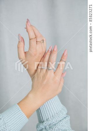 Women's hands manicure and rings are folded in a gentle elegant gesture Women's hands manicure and rings are folded in a gentle elegant gesture 85823271