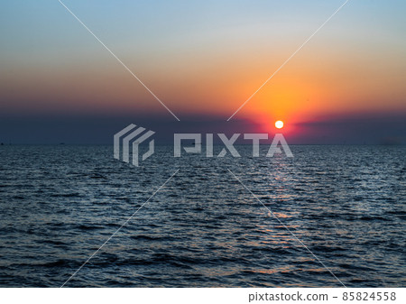 Beautiful sunset over a calm sea with a blue and orange glowing sky. Beautiful sunset over a calm sea with a blue and orange glowing sky. 85824558