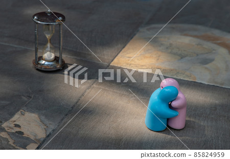 Blue and pink ceramic couple dolls hug with each other on stone background. 85824959