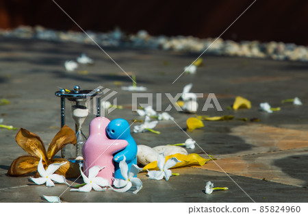 Blue and pink ceramic couple dolls hug with each other on stone background. Blue and pink ceramic couple dolls hug with each other on stone background. 85824960