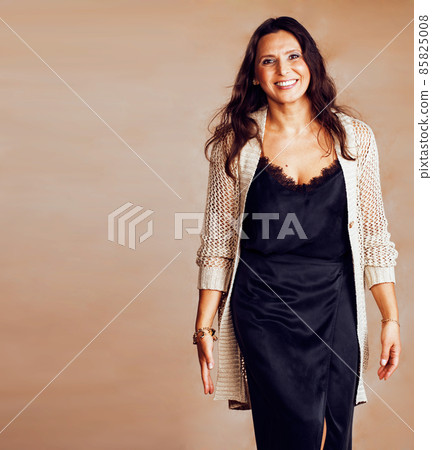 pretty brunette confident mature woman posing cheerful on warm brown background, lifestyle people concept pretty brunette confident mature woman posing cheerful on warm brown background, lifestyle people concept 85825008