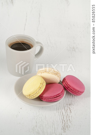 side view colorful macaroons and cup of coffee on wooden table 85826555