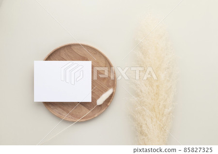 Blank paper cards, Mockup with pampas grass on a wooden plate, beige background, Minimal beige workplace composition, flat lay, mockup Blank paper cards, Mockup with pampas grass on a wooden plate, beige background, Minimal beige workplace composition, flat lay, mockup 85827325