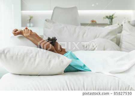Kid in bedroom on bed with white sheet, blanket and pillow. Good morning! 85827530