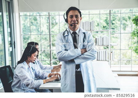 Doctor team wearing headset talking actively on video call in hospital clinic Doctor team wearing headset talking actively on video call in hospital clinic 85829516