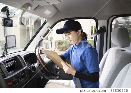 一名女快遞員在車上檢查文件 一名女快遞員在車上檢查文件 85830326