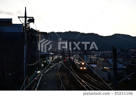 冬日鐵道風光 大燈閃亮的電力機車前駕駛室 在臨近黃昏的鐵軌與山脊線上的特快列車之間穿梭 85831106