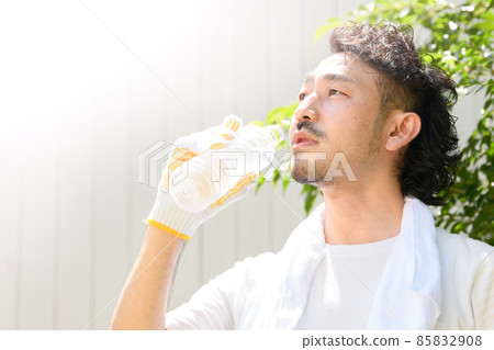 A man working outside to rehydrate in the hot weather A man working outside to rehydrate in the hot weather 85832908