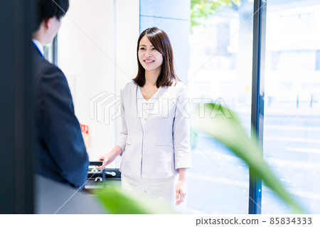 年輕女子與酒店工作人員交談 年輕女子與酒店工作人員交談 85834333
