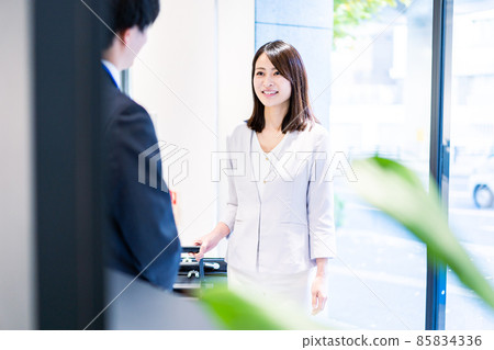 年輕女子與酒店工作人員交談 年輕女子與酒店工作人員交談 85834336