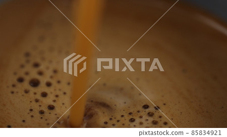 macro of poring espresso into cup from single spout portafilter 85834921