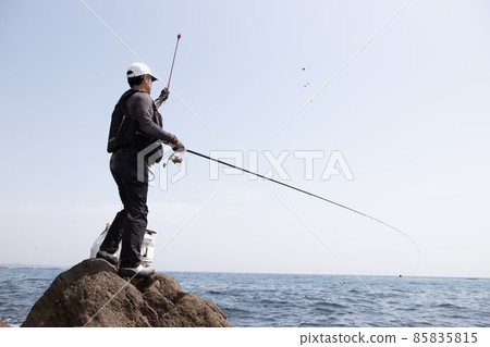 A man fishing on the rocky shore A man fishing on the rocky shore 85835815