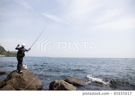 A man fishing on the rocky shore A man fishing on the rocky shore 85835817