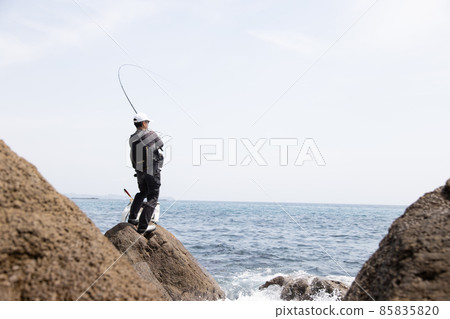 一個在岩石海岸釣魚的人 85835820