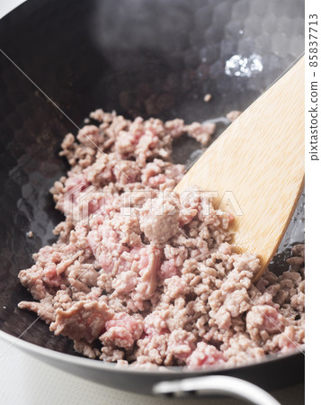 Fry the minced meat in an iron wok 85837713