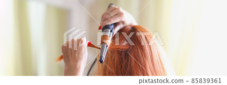 Woman in front of the mirror and doing her hair 85839361