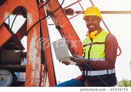 Portrait Black African staff worker happy smile working in cargo crane shipping logistic port. 85839759